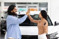 Young indian man and woman giving high five, buying car Royalty Free Stock Photo