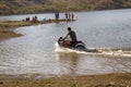 Young Indian rides on pond on sports bike