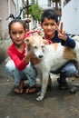 Young Indian siblings, a brother and a sister, joyfully playing with a dog. Heartwarming moment of family bonding and pet