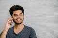 Young indian smiling man talking on his phone