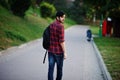 Young indian student man at red checkered shirt