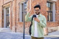 Young indian student received online win notification message phone, successful entrance exam results, man with backpack Royalty Free Stock Photo