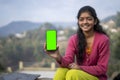 Young indian village girl showing a mobile phone with green screen Royalty Free Stock Photo