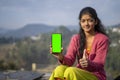 Young indian village girl showing a mobile phone with green screen with thumbs up Royalty Free Stock Photo