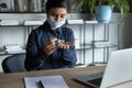 Young Indian woman in face mask cleanse hands with sanitizer