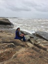 A young Indian woman posing on rocky shores of Kundapura