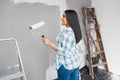 A young Indian woman prepares to paint a wall during home DIY project