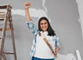 Young Indian woman raises fist proud of DIY construction progress carry timber