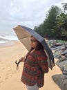 A young Indian woman under umbrella at the Kundapura beach Royalty Free Stock Photo