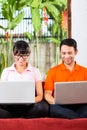 Asian couple on the couch with a laptop