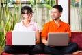 Asian couple on the couch with a laptop