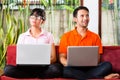 Asian couple on the couch with a laptop