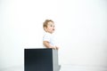 A young infant boy peeking out of a box on a white background Royalty Free Stock Photo