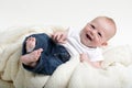 Young infant with a hearty laugh wearing jeans