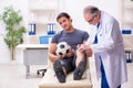 Young injured soccer player visiting old doctor traumatologist