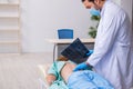 Young back injured woman visiting male doctor chiropractor Royalty Free Stock Photo