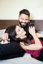 Young inlove couple on the bed with their cats