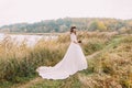 Young innocent bride posing outdoors. Cute charming girl with forest hills on background Royalty Free Stock Photo