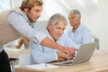 Young instructor helping senior man in class Royalty Free Stock Photo