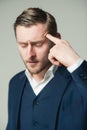 Young intellectual with closed eyes dealing with problem Portrait of tired businessman pressing his pointing finger on Royalty Free Stock Photo