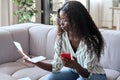 Young intelligent mixed race businesswoman sitting with papers using cellphone. Royalty Free Stock Photo