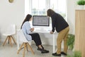 Young interior designers man and woman looking floor plan of new house on computer monitor screen. Royalty Free Stock Photo