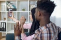 Diverse couple using smartphone for video call with family Royalty Free Stock Photo