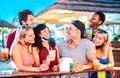Young international friends talking at beach cocktail bar with open face mask - New normal tourism concept with millennial people Royalty Free Stock Photo