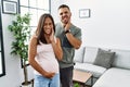 Young interracial couple expecting a baby, touching pregnant belly touching mouth with hand with painful expression because of Royalty Free Stock Photo