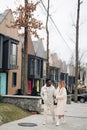 Young interracial couple holds each other hand and walks on street