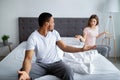 Young interracial couple quarreling in bedroom, being angry, facing family problems. Marriage crisis, divorce concept Royalty Free Stock Photo