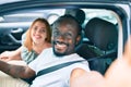 Young interracial couple smiling happy making selfie by the camera at the car Royalty Free Stock Photo