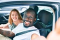 Young interracial couple smiling happy making selfie by the camera at the car Royalty Free Stock Photo