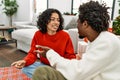 Young interracial couple smiling happy and speaking sitting on the floor at home Royalty Free Stock Photo