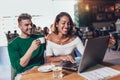 Young interracial couple spending time in cafe watching media on laptop Royalty Free Stock Photo