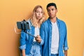 Young interracial couple taking a selfie photo with smartphone depressed and worry for distress, crying angry and afraid Royalty Free Stock Photo