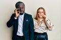 Young interracial couple wearing business and elegant clothes mouth and lips shut as zip with fingers Royalty Free Stock Photo