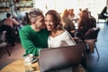 Young interracial lovers spending time in cafe watching media on laptop Royalty Free Stock Photo