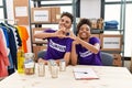 Young interracial people wearing volunteer t shirt at donations stand smiling in love doing heart symbol shape with hands Royalty Free Stock Photo