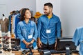 Young interracial people working at retail boutique smiling looking to the side and staring away thinking Royalty Free Stock Photo