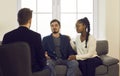 Young interracial spouses talking to man specialist at family consultation Royalty Free Stock Photo