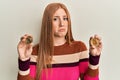 Young irish woman holding virtual currency ethereum coin and bitcoin depressed and worry for distress, crying angry and afraid