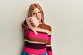 Young irish woman wearing casual clothes looking unhappy and angry showing rejection and negative with thumbs down gesture Royalty Free Stock Photo