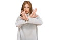 Young irish woman wearing casual winter sweater rejection expression crossing arms doing negative sign, angry face