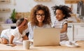 Young irritated African-American mother freelancer trying to work while working remotely with kids Royalty Free Stock Photo