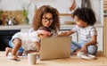 Young irritated African-American mother freelancer trying to work while working remotely with kids Royalty Free Stock Photo