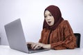 Young Islam woman is shock when holding and working on laptop computer isolated white background Royalty Free Stock Photo