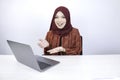 Young Islam woman is smiling pointing hand when working on laptop on white background