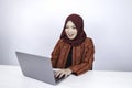 Young Islam woman wearing headscarf is shocked and excited with what she see on laptop on the table