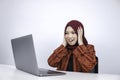 Young Islam woman wearing headscarf is shocked and excited with what she see on laptop on the table